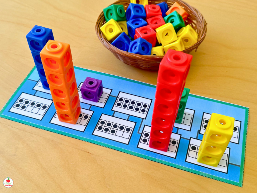 Build a City number sense activity mat with colorful math cube towers of different heights built on ten frame number cards