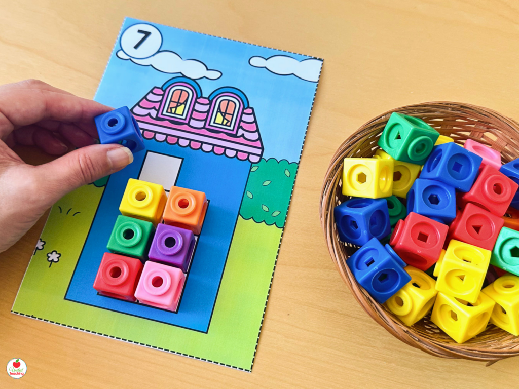 Number sense activity mat showing a child counting 7 colorful math cubes onto a house-shaped mat for kindergarten counting practice