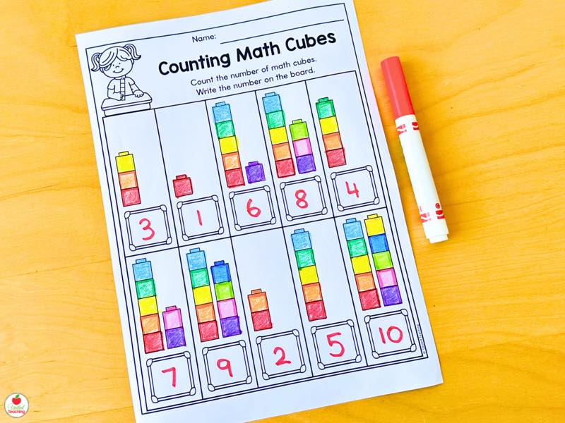 Counting Math Cubes worksheet with towers of colorful cubes counted and written on a whiteboard
