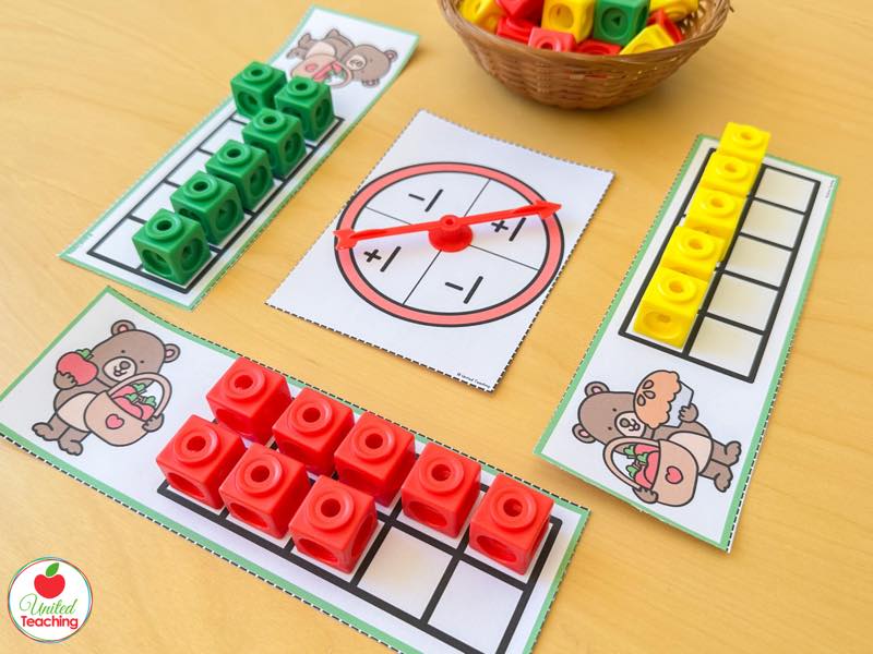 Apple ten frame strips with a plus 1 minus 1 spinner and red green and yellow math cubes