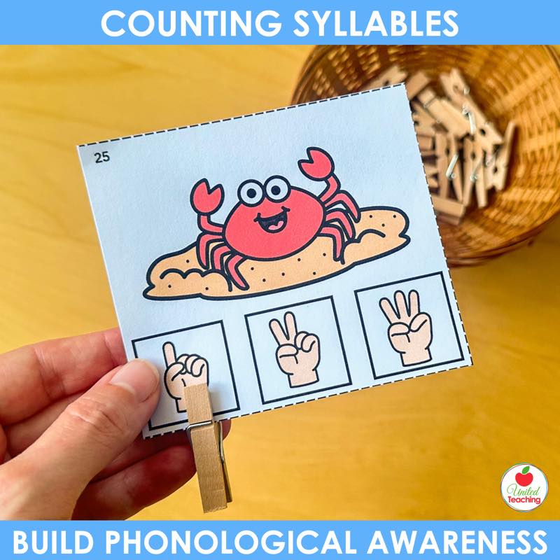 A hand clipping a clothespin to the one finger square on a crab counting syllables clip card