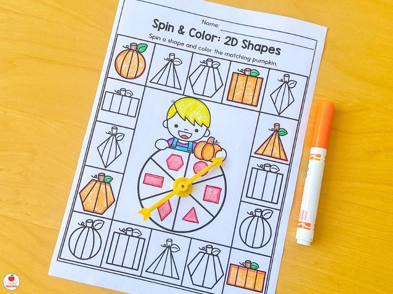 Fall spin and color 2D shapes worksheet for kindergarten with a paper clip spinner and pumpkins