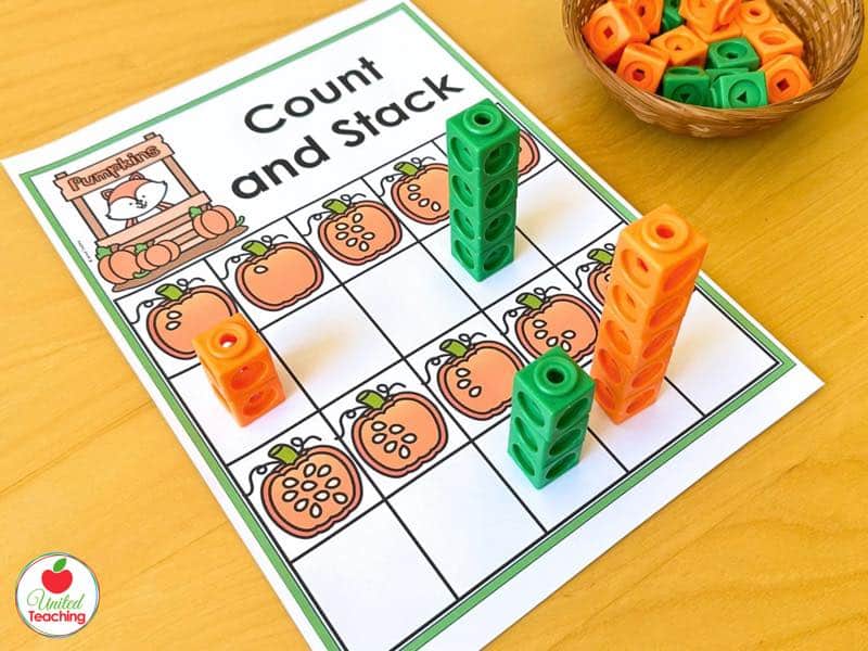 Pumpkin count and stack mat with orange and green math cube towers matching the seeds in each pumpkin