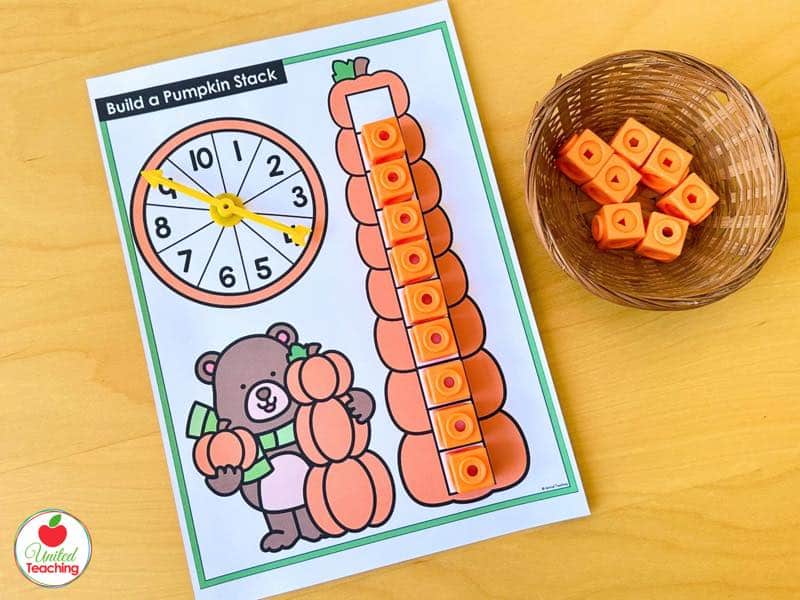 Spin and Build a Pumpkin Stack mat with a 1 to 10 spinner and an orange math cube tower
